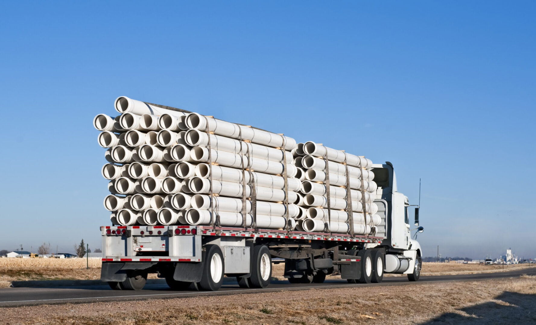A semi truck hauling multiple loads on the road.